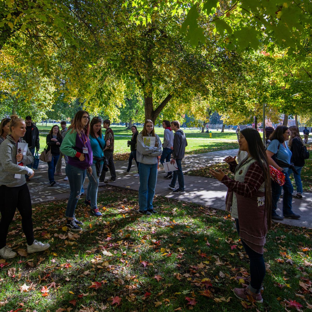 Students and families at a previous year's Griz Preview Day outside on lawn with a tour guide on a beautiful fall day.